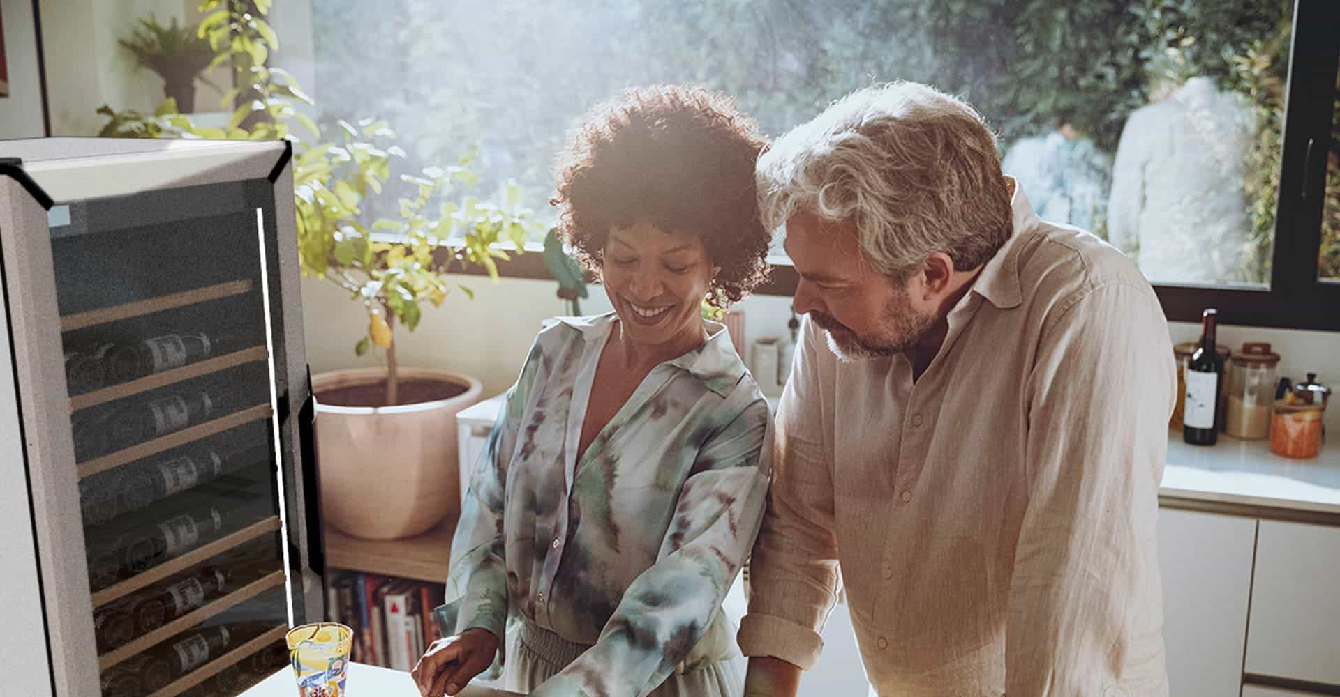 Un homme et une femme dans une cuisine derrière une grande baie vitrée