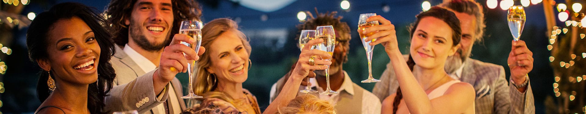 Six personnes souriantes lèvent leur coupe de champagne